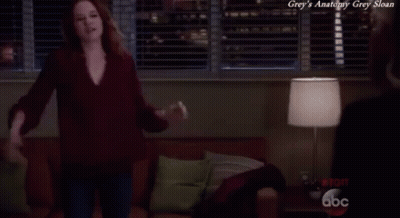 A Woman Is Dancing In A Living Room With The Words Grey 'S Anatomy Grey Sloan Written Above Her GIF