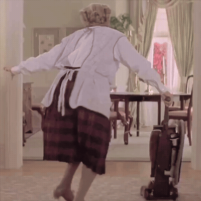 A Woman Is Dancing In A Room With A Vacuum Cleaner GIF