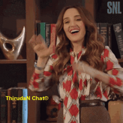 A Woman Is Dancing In Front Of A Bookshelf With The Word Snl In The Corner GIF
