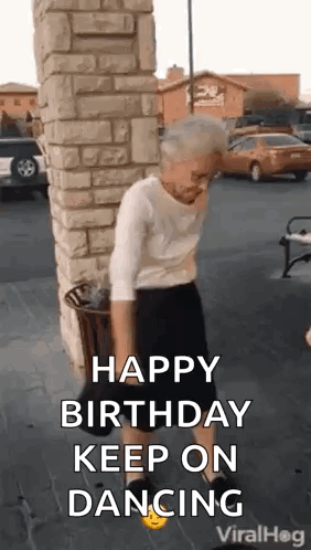 A Woman Is Dancing In Front Of A Brick Wall . GIF