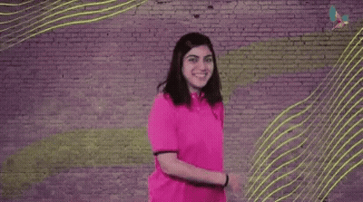 A Woman Is Dancing In Front Of A Brick Wall With The Words `` We Got This '' Written On It . GIF