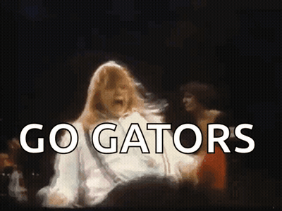 A Woman Is Dancing In Front Of A Crowd And The Words Go Gators Are Visible GIF