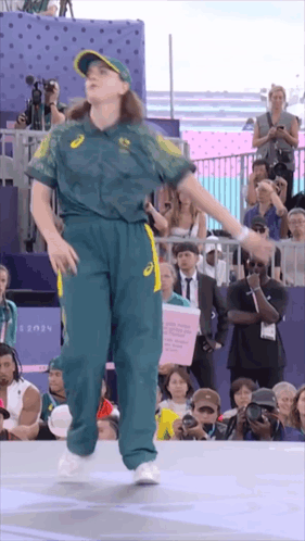 A Woman Is Dancing In Front Of A Crowd With A Sign That Says 2024 On It GIF