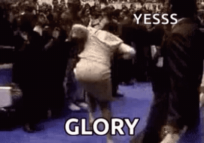 A Woman Is Dancing In Front Of A Crowd With The Words `` Glory '' Written On The Bottom . GIF