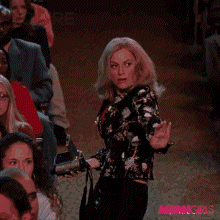 A Woman Is Dancing In Front Of A Crowd With The Words " You 'Re Doing " Behind Her GIF