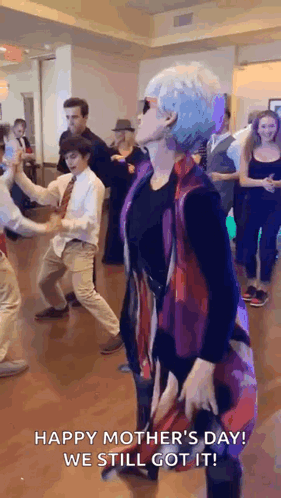 A Woman Is Dancing In Front Of A Group Of People . GIF