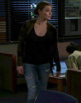 A Woman Is Dancing In Front Of A Laptop In A Room GIF