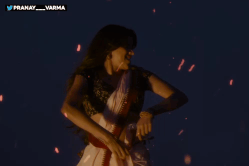 A Woman Is Dancing In Front Of A Sign That Says Pranay GIF
