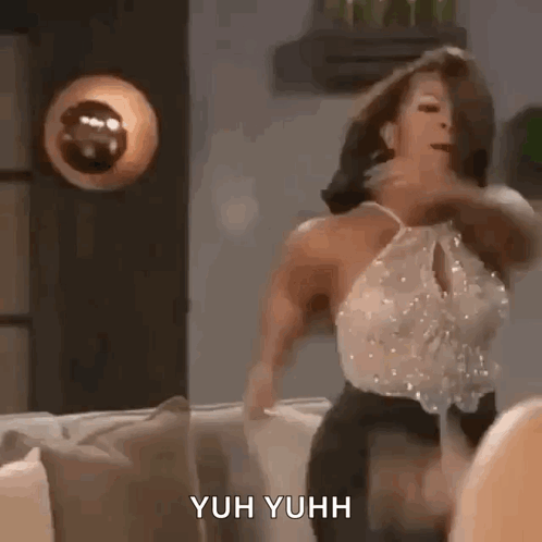 A Woman Is Dancing On A Couch In A Living Room With A Lamp In The Background . GIF