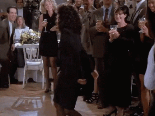 A Woman Is Dancing On A Dance Floor In Front Of A Crowd Of People Holding Wine Glasses . GIF