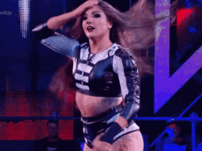 A Woman Is Dancing On A Stage In A Wrestling Ring . GIF