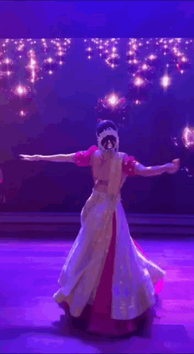 A Woman Is Dancing On A Stage In Front Of A Blue Background GIF