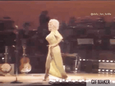 A Woman Is Dancing On A Stage In Front Of A Microphone . GIF