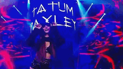 A Woman Is Dancing On A Stage With A Sign That Says Atum Ey . GIF