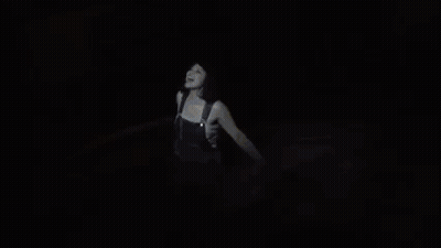 A Woman Is Dancing On A Stage With A Sword In Her Hand GIF