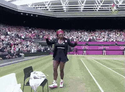 A Woman Is Dancing On A Tennis Court In Front Of A Large Crowd GIF