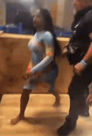 A Woman Is Dancing With A Police Officer In A Video . GIF