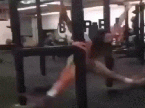 A Woman Is Doing A Handstand In A Gym . GIF