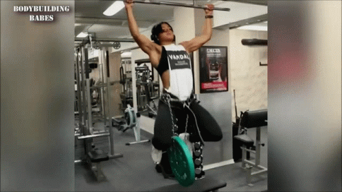 A Woman Is Doing A Pull Up In A Gym And The Words Bodybuilding Babes Are On The Bottom GIF