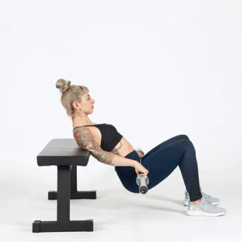 A Woman Is Doing Exercises On A Bench With A Dumbbell GIF