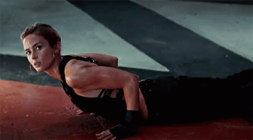 A Woman Is Doing Push Ups On The Floor In A Dark Room . GIF