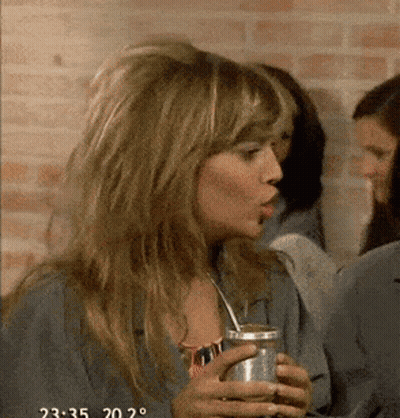 A Woman Is Drinking A Can Of Soda With A Straw And The Time Is 2:35 GIF