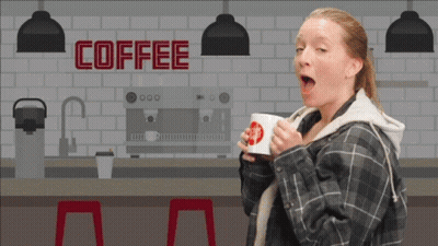 A Woman Is Drinking A Cup Of Coffee In Front Of A Sign That Says Coffee GIF