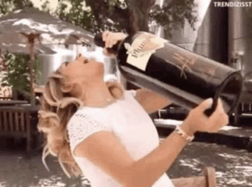 A Woman Is Drinking A Large Bottle Of Wine From Her Head . GIF