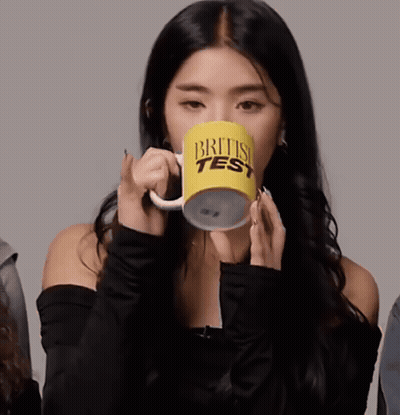 A Woman Is Drinking From A British Test Mug GIF
