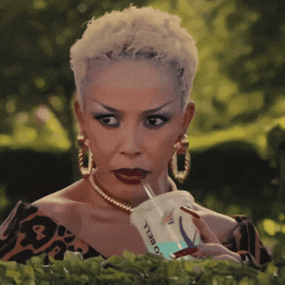 A Woman Is Drinking From A Cup That Says O Bell GIF
