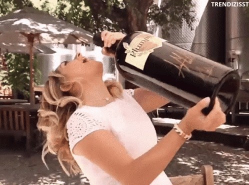 A Woman Is Drinking From A Large Bottle Of Plum Wine GIF