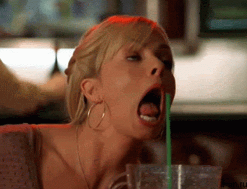 A Woman Is Drinking Through A Green Straw With Her Tongue Out GIF