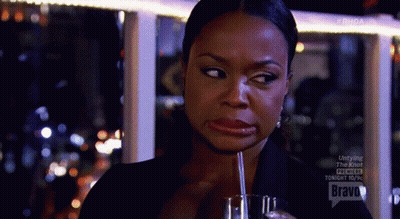 A Woman Is Drinking Through A Straw From A Glass And Making A Funny Face . GIF