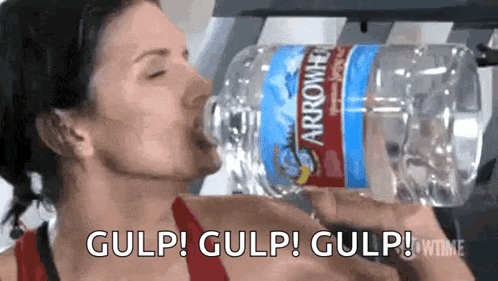 A Woman Is Drinking Water From A Bottle That Says Arrowhead On It GIF