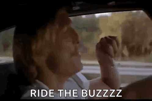 A Woman Is Driving A Car With The Words `` Ride The Buzz '' Written On The Screen . GIF
