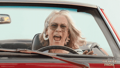 A Woman Is Driving A Red Car With The Words Freakier Friday Written On The Side GIF