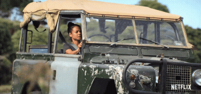 A Woman Is Driving A Vehicle That Says Netflix On The Side GIF