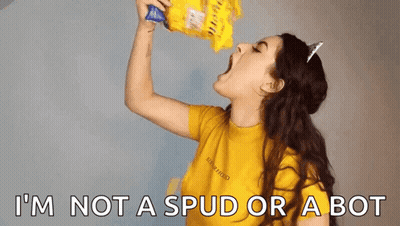 A Woman Is Eating A Bag Of Chips With The Words I 'M Not A Spud Or A Bot Below Her . GIF