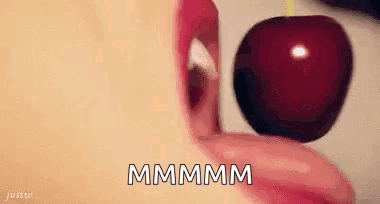 A Woman Is Eating A Cherry With Her Tongue . GIF