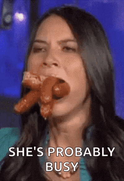 A Woman Is Eating A Hot Dog With The Words `` She 'S Probably Busy '' Written Below Her . GIF