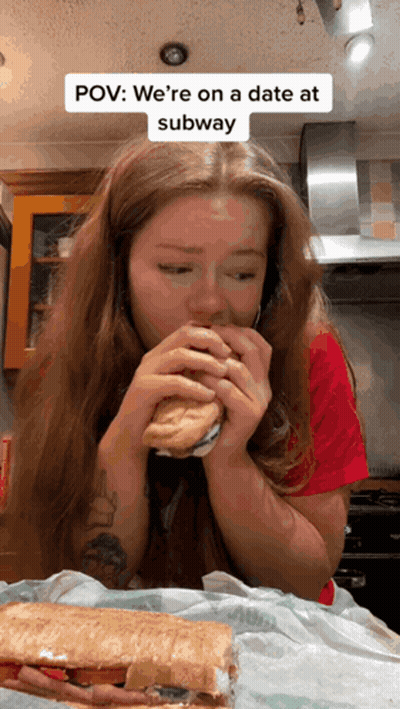 A Woman Is Eating A Subway Sandwich With A Caption That Says Pov We 'Re On A Date At Subway GIF