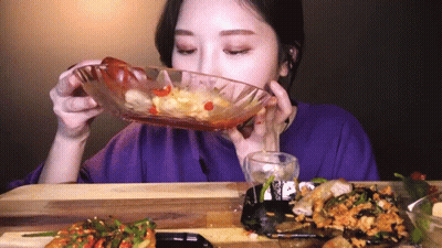 A Woman Is Eating Food From A Glass Bowl GIF