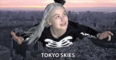 A Woman Is Flying Through The Air In A Tokyo Skies Shirt . GIF