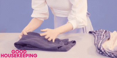 A Woman Is Folding Clothes And The Words Good Housekeeping Are Above Her GIF