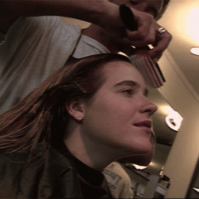A Woman Is Getting Her Hair Brushed By A Hairdresser GIF
