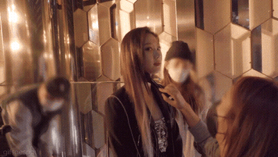 A Woman Is Getting Her Hair Done In Front Of A Mirror While Another Woman Looks On GIF