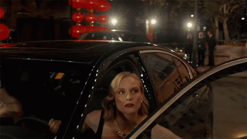A Woman Is Getting Out Of A Car In Front Of Chinese Lanterns GIF
