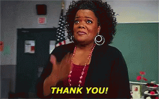 A Woman Is Giving A Thank You Gesture In Front Of An American Flag GIF