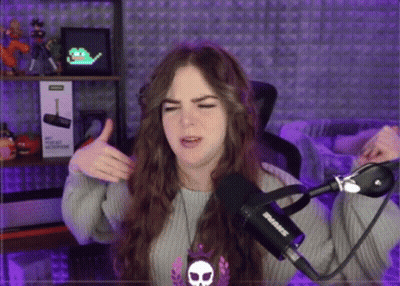 A Woman Is Giving A Thumbs Up In Front Of A Microphone That Says Shure GIF