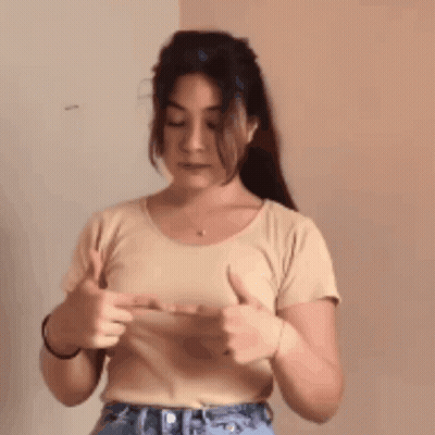 A Woman Is Giving A Thumbs Up Sign With Her Hands GIF